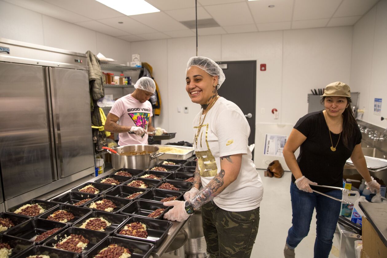 ChiFresh Kitchen is a cooperative food service contractor in Garfield Park, owned and operated by formerly incarcerated individuals. (L-R) Daniel McWillliams and Sarah Stadtseld cook and package meals, assisted by Camille Kerr, co-founder of the social enterprise awarded an American Heart Associations Social Impact Fund grant.